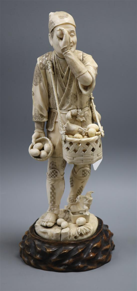 A Meiji carved ivory figure of a man inspecting bird eggs, a sectional carving